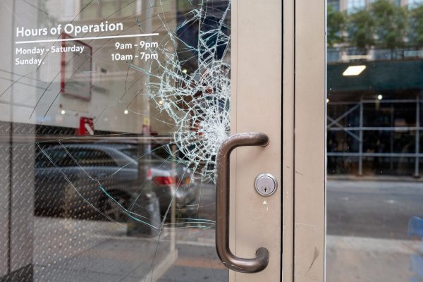 Broken shattered window on store front aluminum door from vandals.